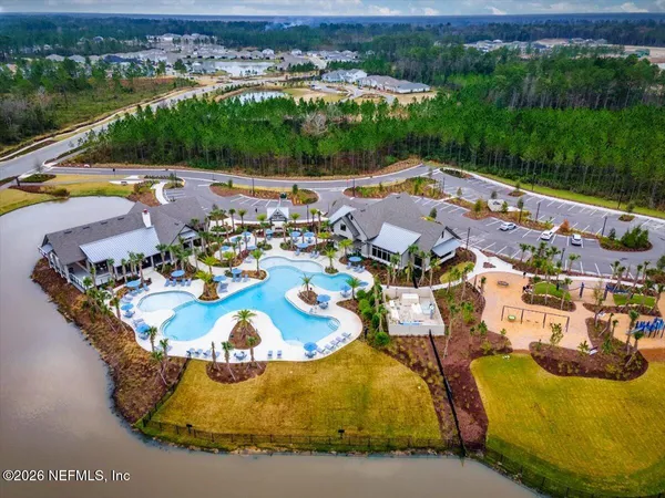 an aerial view of a house with swimming pool and lake view