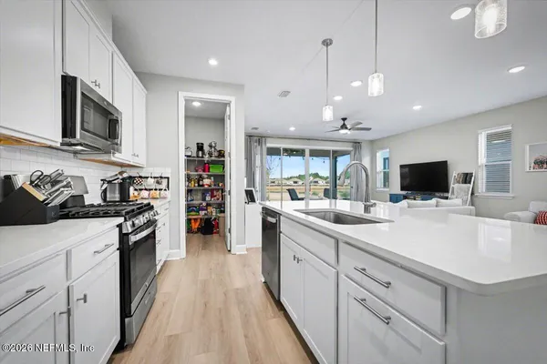 a large kitchen with stainless steel appliances granite countertop a lot of counter space and a sink