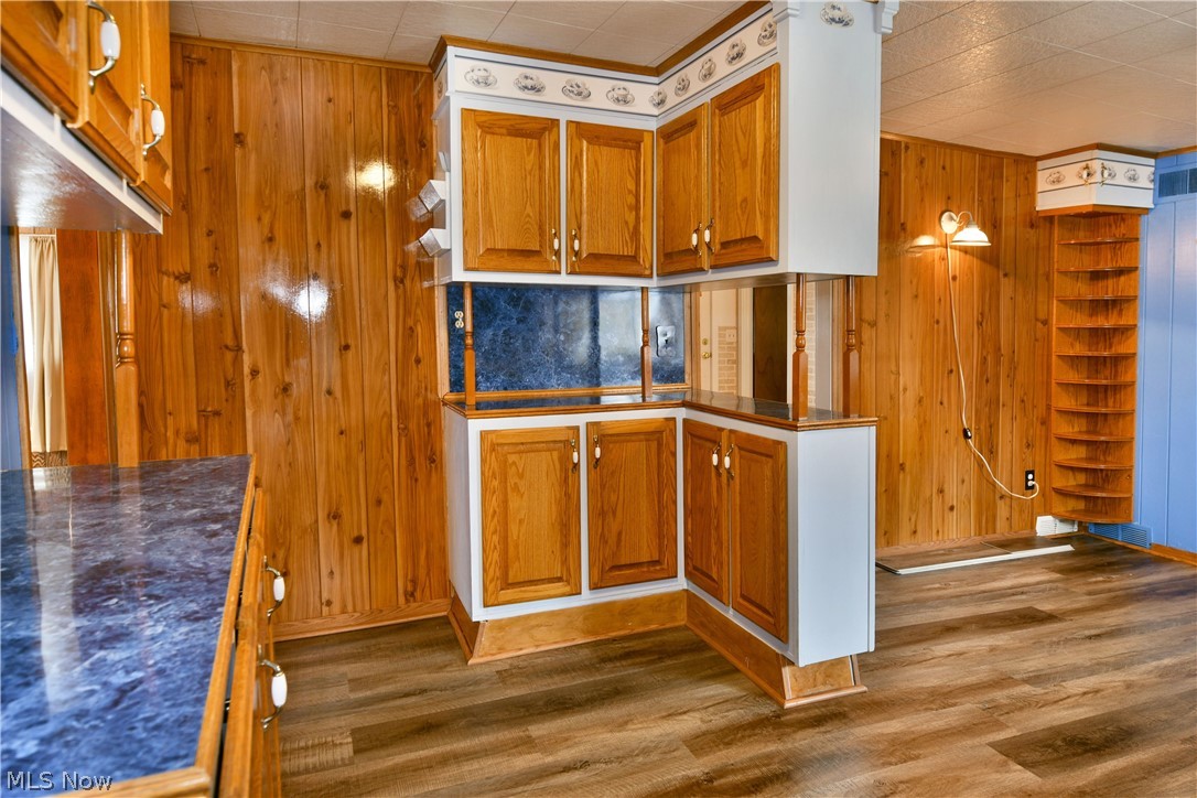 878 Ridge Road Vienna, OH 44473 - Photo 20 of 50 Kitchen featuring dark countertops, wood finish cabinets, dark wood-type flooring, and wooden walls