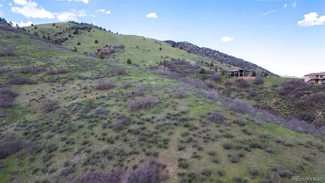 a view of a dry field with mountains in the background