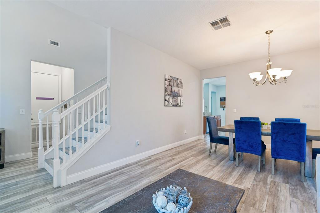 3620 Lefays Point Land O Lakes, FL 34638 - Photo 5 of 50 a dining room with wooden floor a chandelier a wooden table and chairs