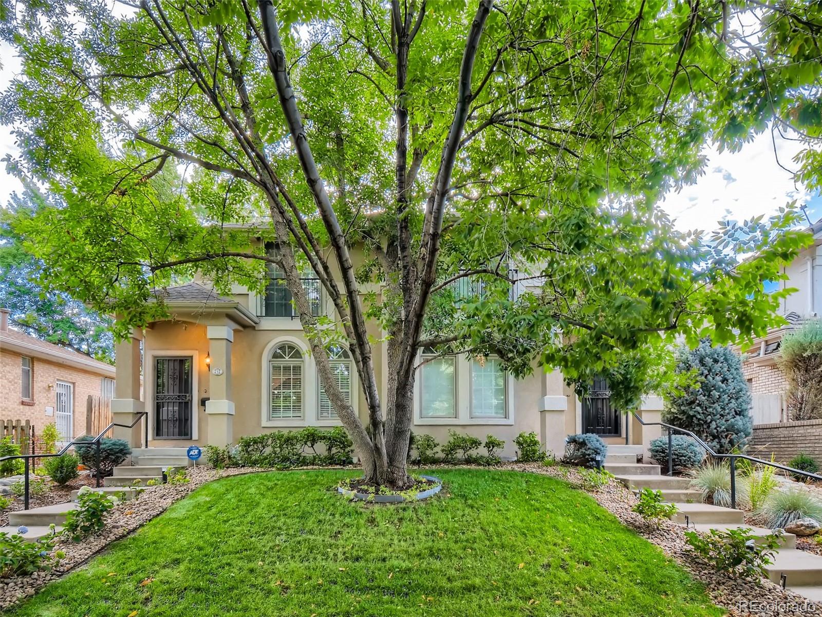 a view of a house with backyard and a tree