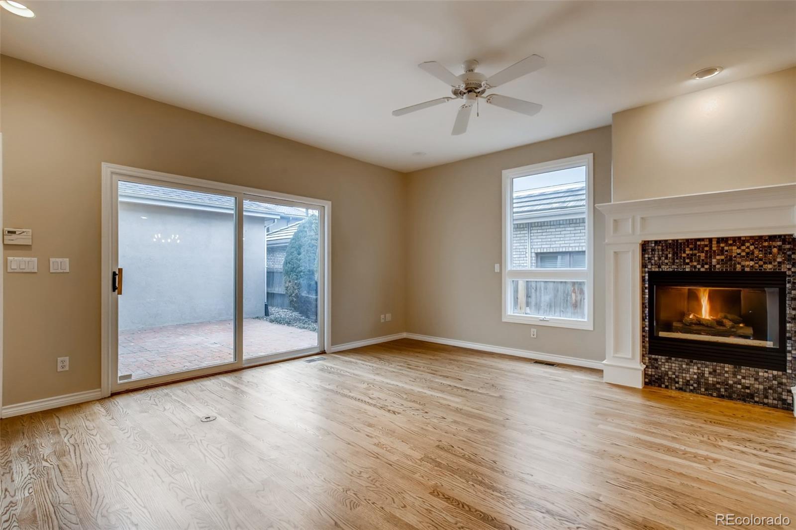 210 Cook Street Denver, CO 80206 - Photo 11 of 34 an empty room with wooden floor fan and windows
