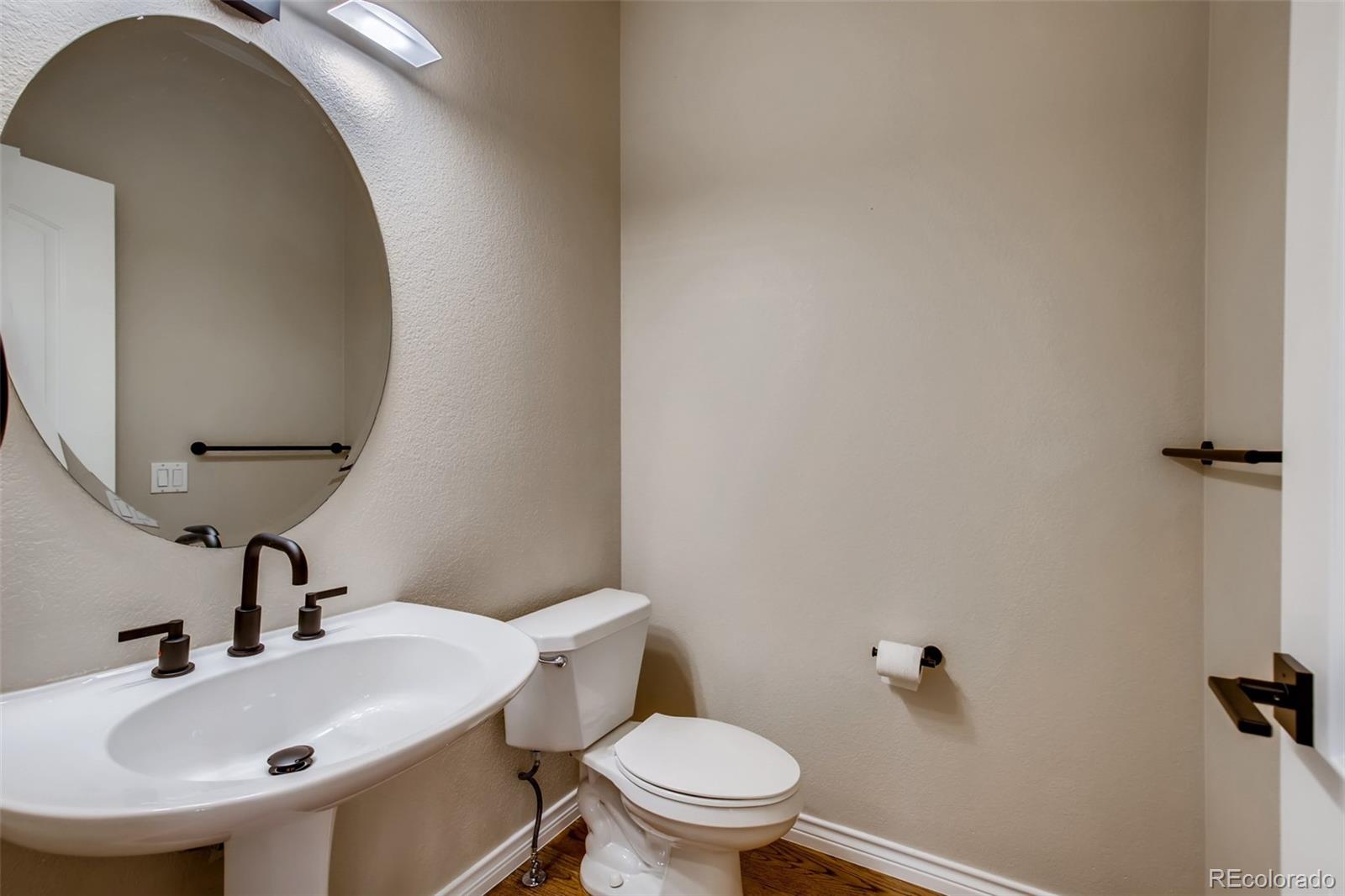 210 Cook Street Denver, CO 80206 - Photo 12 of 34 a bathroom with a sink and mirror with toilet