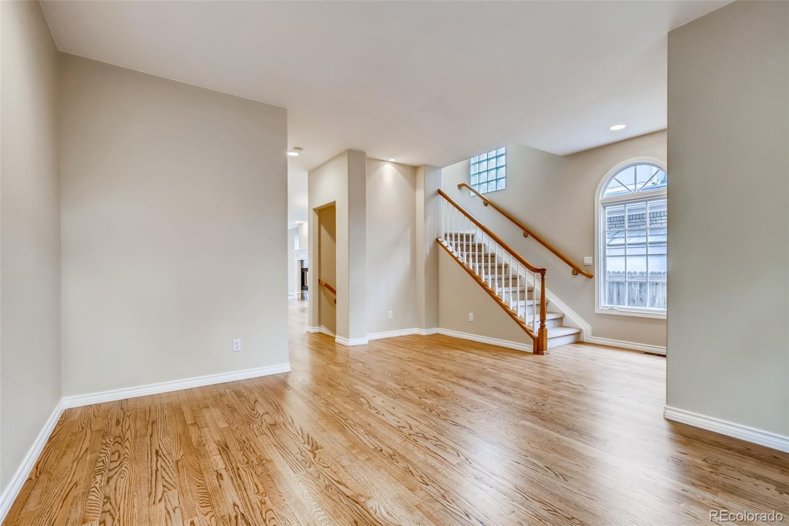 210 Cook Street Denver, CO 80206 - Photo 15 of 34 a view of an empty room with wooden floor and stairs