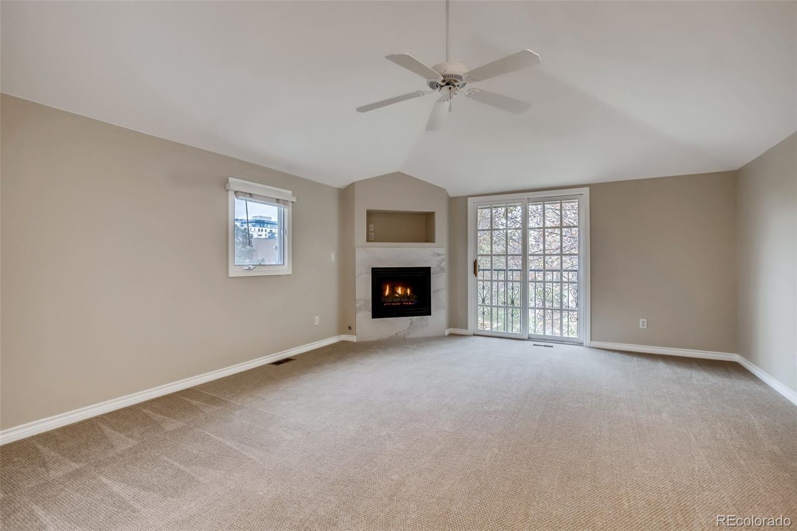 210 Cook Street Denver, CO 80206 - Photo 17 of 34 a view of an empty room with chandelier fan and fire place