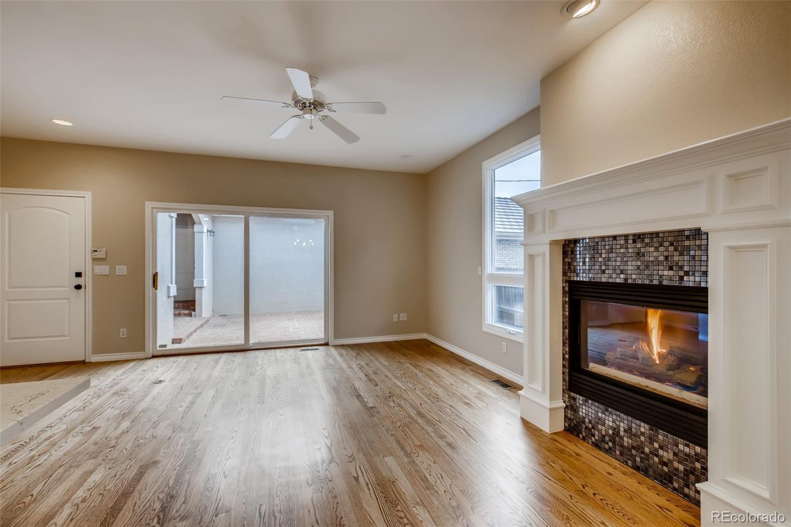 210 Cook Street Denver, CO 80206 - Photo 9 of 34 a view of an empty room with wooden floor fireplace and a window