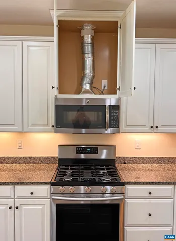 a stove top oven sitting inside of a kitchen