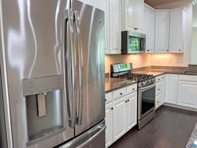 a kitchen with stainless steel appliances granite countertop a refrigerator sink and stove