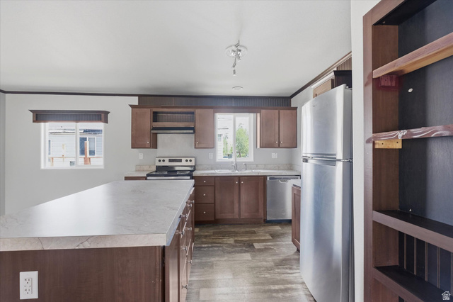433 North 750 West Logan, UT 84321 - Photo 9 of 40 Kitchen featuring an island with a light-toned countertop, wood-finish cabinetry, stainless steel appliances, and wood-finish flooring