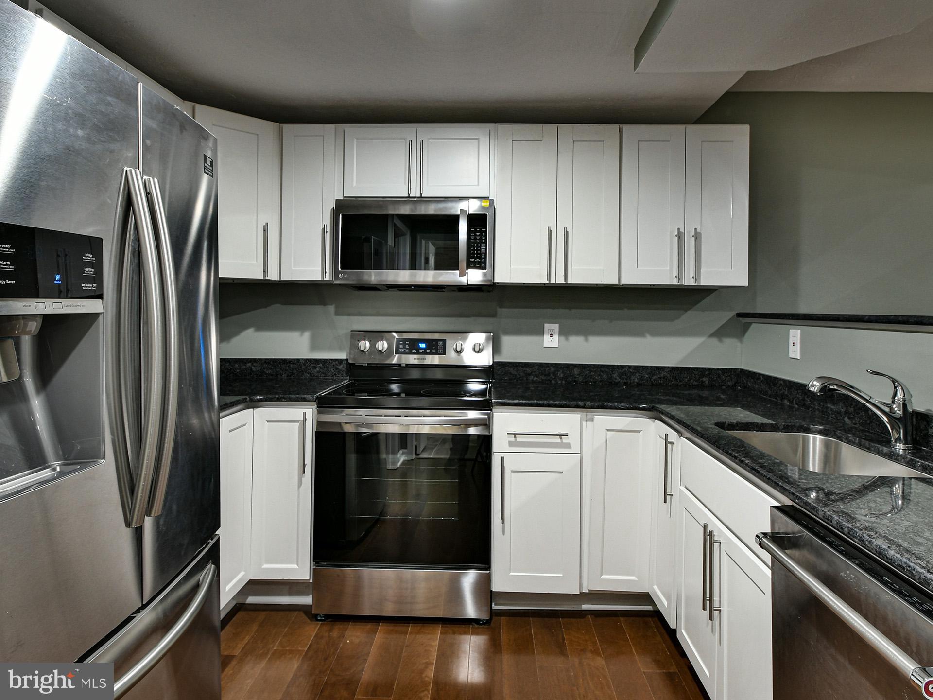 3511 Castle Way, Unit 312 Silver Spring, MD 20904 - Photo 5 of 20 a kitchen with stainless steel appliances granite countertop a stove a refrigerator and a microwave