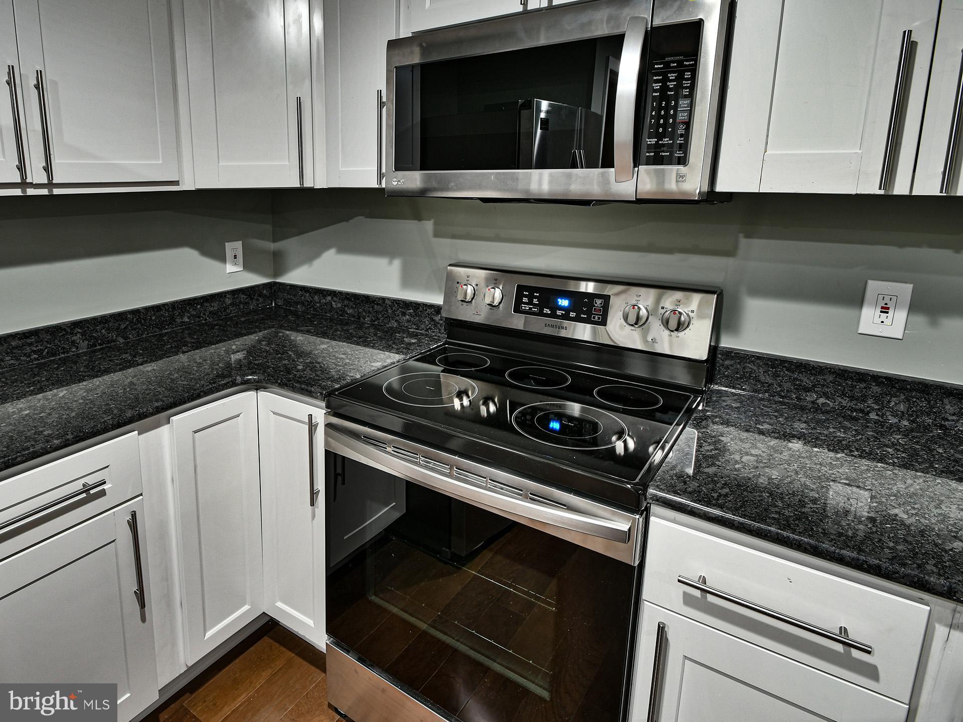 3511 Castle Way, Unit 312 Silver Spring, MD 20904 - Photo 8 of 20 a kitchen with a stove and white cabinets