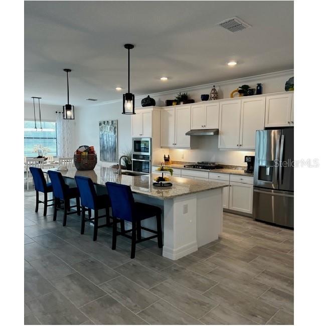 17021 Polo Trail Lakewood Ranch, FL 34211 - Photo 15 of 42 a kitchen with stainless steel appliances granite countertop a stove a sink a refrigerator and a dining table