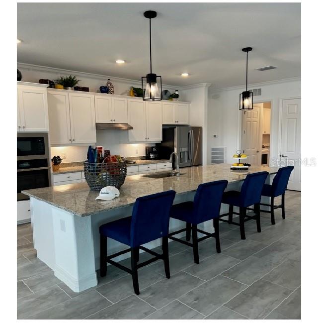 17021 Polo Trail Lakewood Ranch, FL 34211 - Photo 16 of 42 a kitchen with a dining table chairs and sink