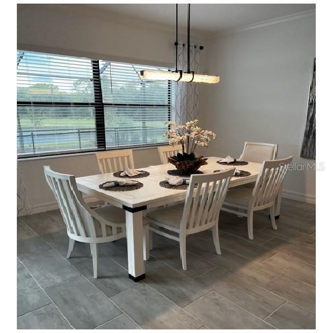 17021 Polo Trail Lakewood Ranch, FL 34211 - Photo 17 of 42 a dining room with furniture a chandelier and window