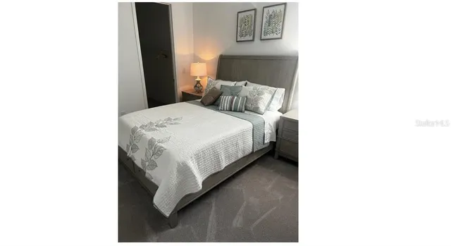 a bedroom with a bed and a night stand