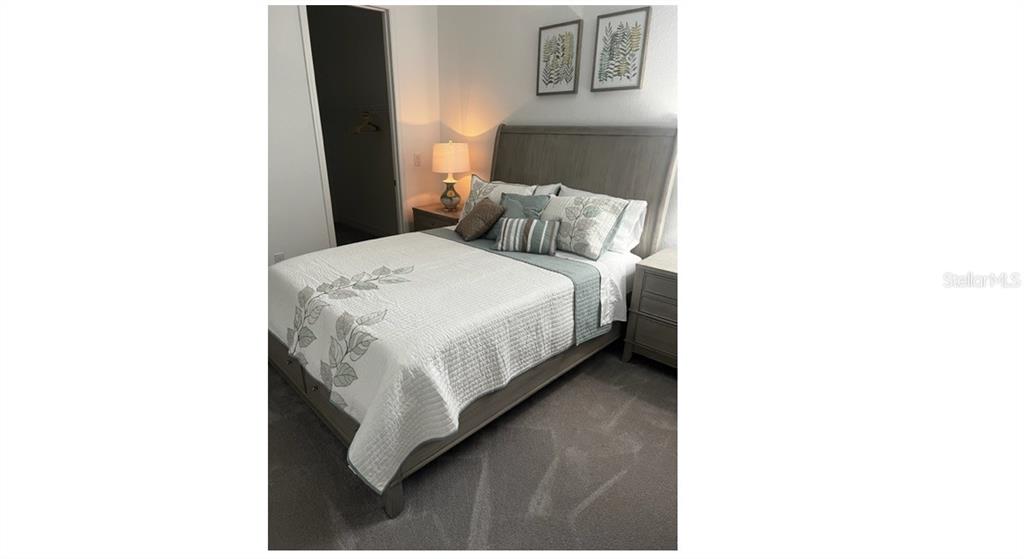 17021 Polo Trail Lakewood Ranch, FL 34211 - Photo 27 of 42 a bedroom with a bed and a night stand