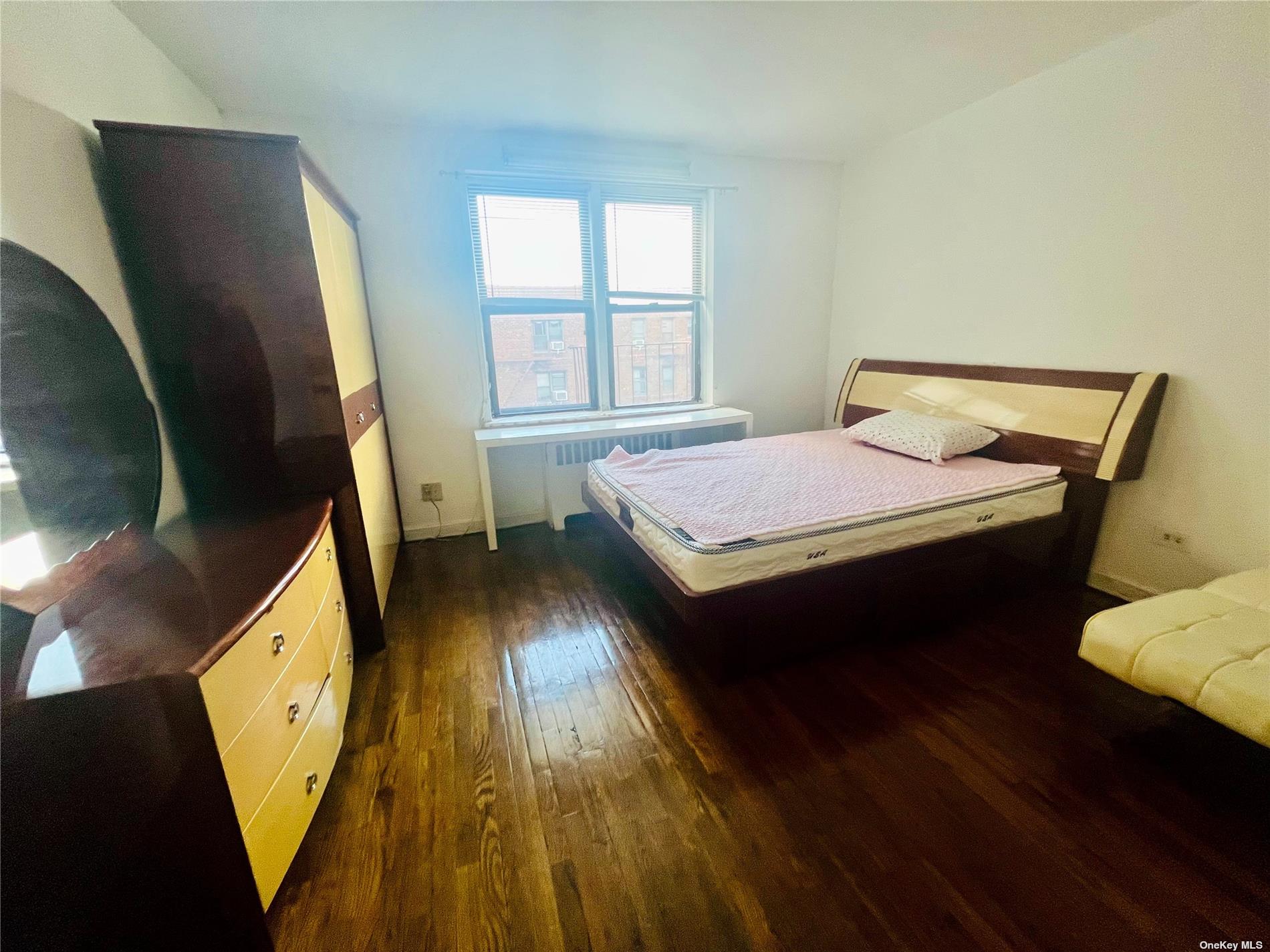 a spacious bedroom with a bed and wooden floor