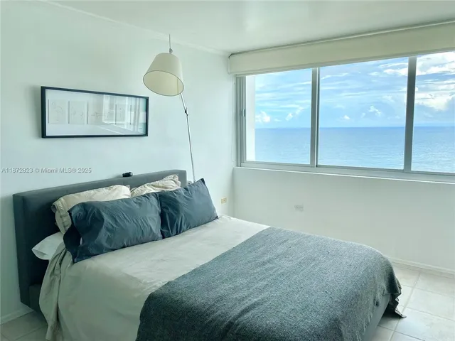 a bedroom with a bed mirror and window
