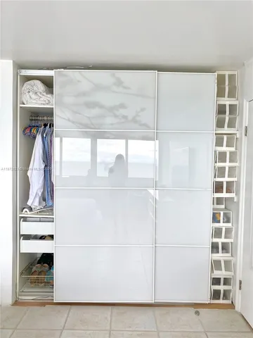 a view of walk in closet with clothes and shoes