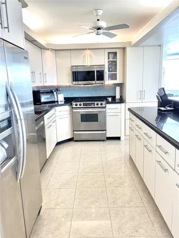 a kitchen with stainless steel appliances granite countertop a stove top oven microwave and a refrigerator