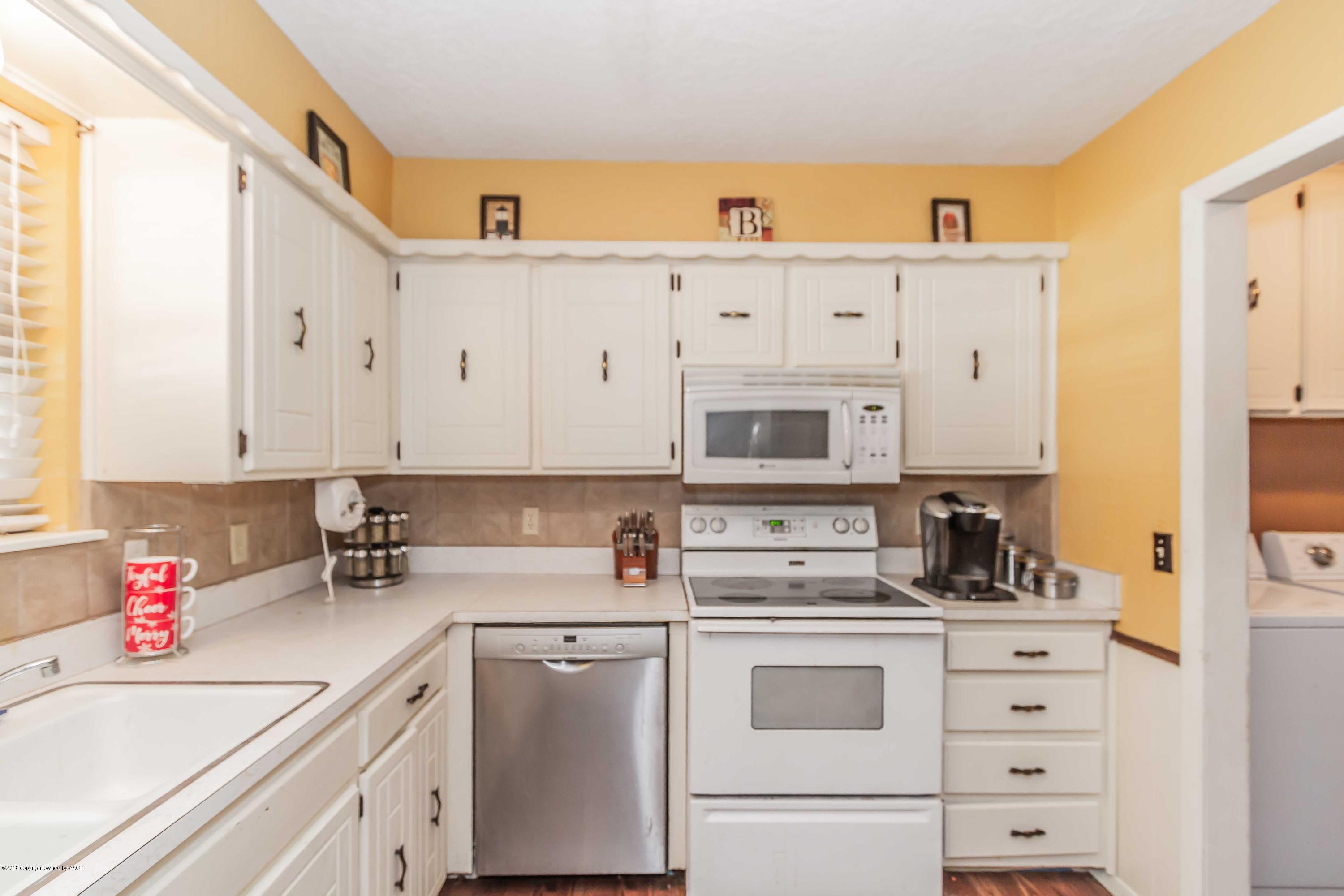 5205 South Milam Street Amarillo, TX 79110 - Photo 5 of 23 a kitchen with cabinets appliances a sink and a counter top space