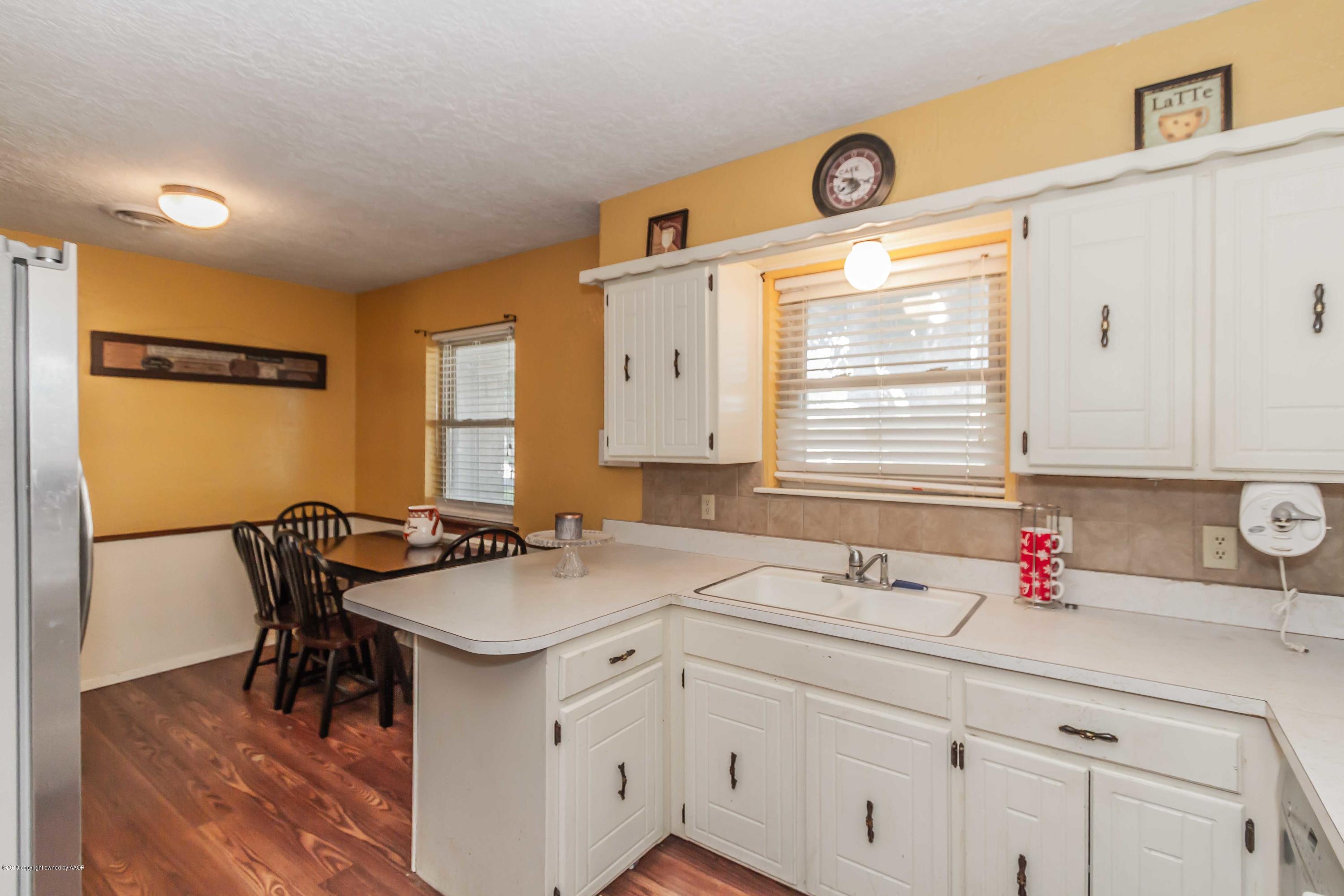 5205 South Milam Street Amarillo, TX 79110 - Photo 6 of 23 a kitchen with a sink cabinets and wooden floor