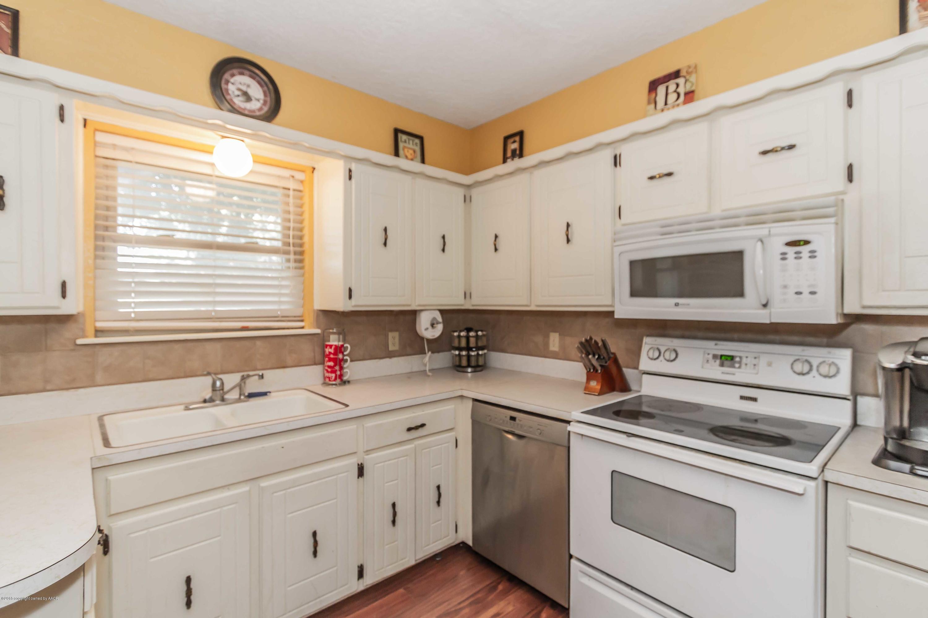 5205 South Milam Street Amarillo, TX 79110 - Photo 7 of 23 a kitchen with cabinets appliances a sink and a window