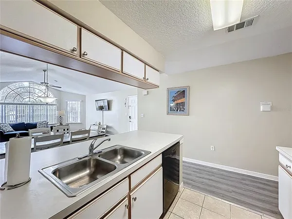 a kitchen with a sink and a stove top oven with wooden floor