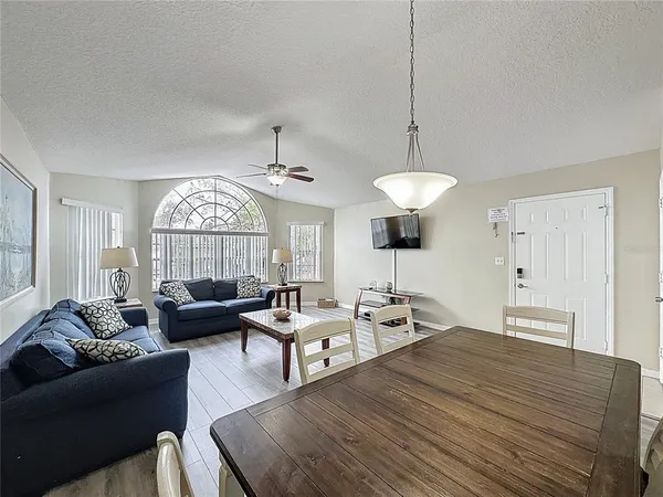 a living room with furniture a chandelier and a window