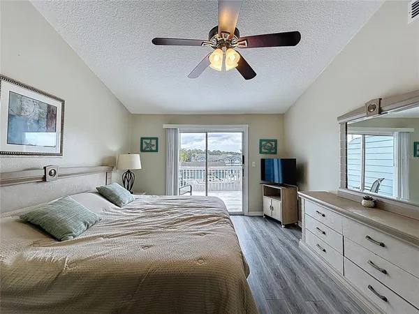 a bedroom with a large bed and a flat tv screen on dresser