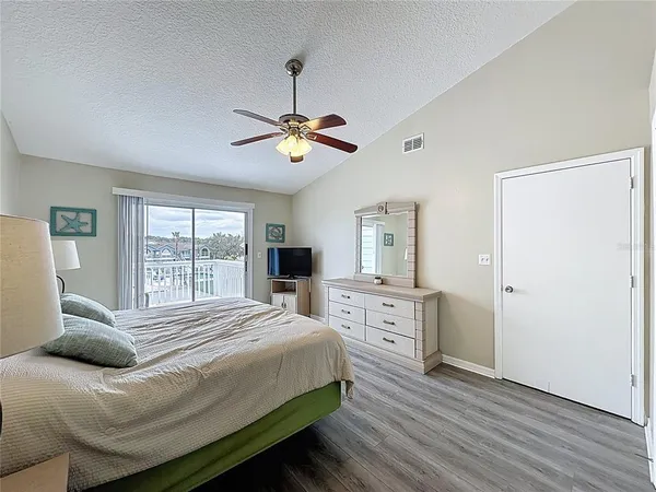 a bedroom with a large bed a chandelier and dresser