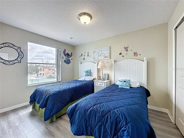 a bedroom with two beds and painting on the wall
