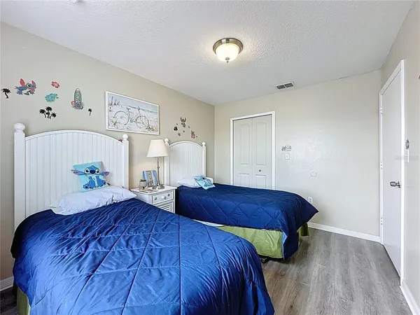 a bedroom with a bed and a wooden floor