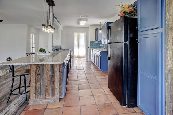 a kitchen with stainless steel appliances granite countertop a refrigerator and a sink