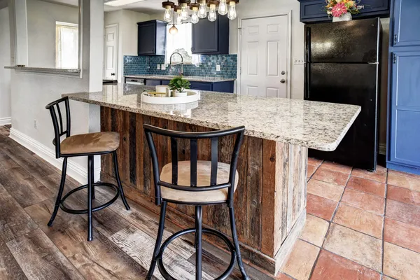 a kitchen with a table chairs and refrigerator