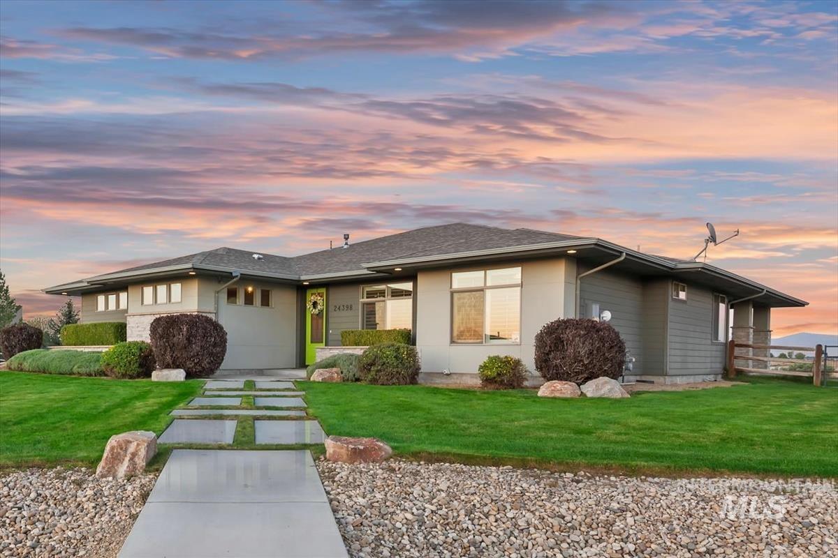 24398 Tombstone Ridge Court Middleton, ID 83644 - Photo 38 of 48 Modern ranch exterior featuring a vibrant green entry door, a split concrete and grass walkway, and mature landscaping