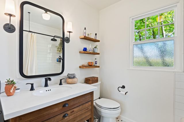 a bathroom with a sink mirror vanity and toilet