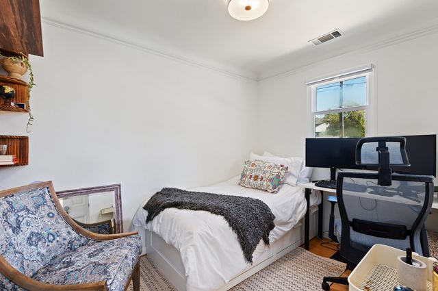 a bedroom with a bed chair and a window