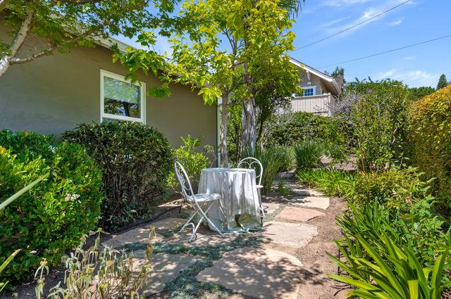 a view of a house with a small yard and potted plants