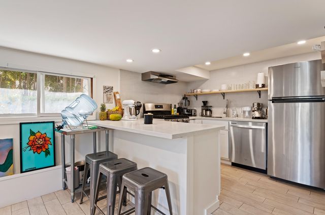 a kitchen with white cabinets and stainless steel appliances