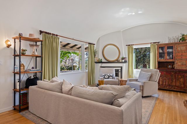a living room with furniture a fireplace and a floor to ceiling window