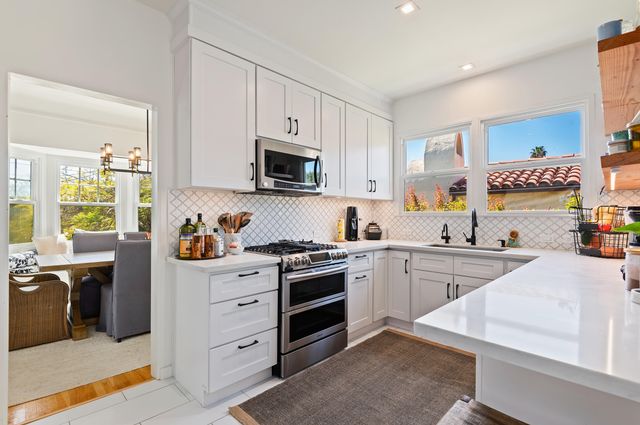 a kitchen with cabinets appliances and a window