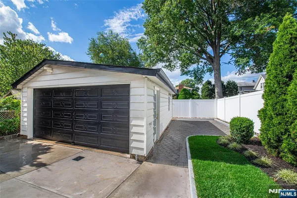 a view of a house with a small yard plants and large tree