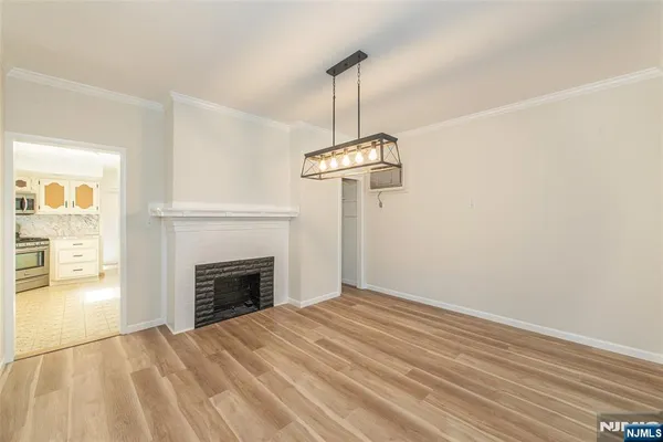 a view of empty room with a fireplace and wooden floor
