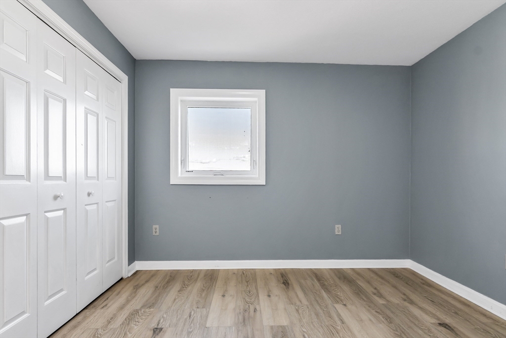 165 Cottage Street, Unit 711 Chelsea, MA 02150 - Photo 20 of 39 an empty room with wooden floor and windows