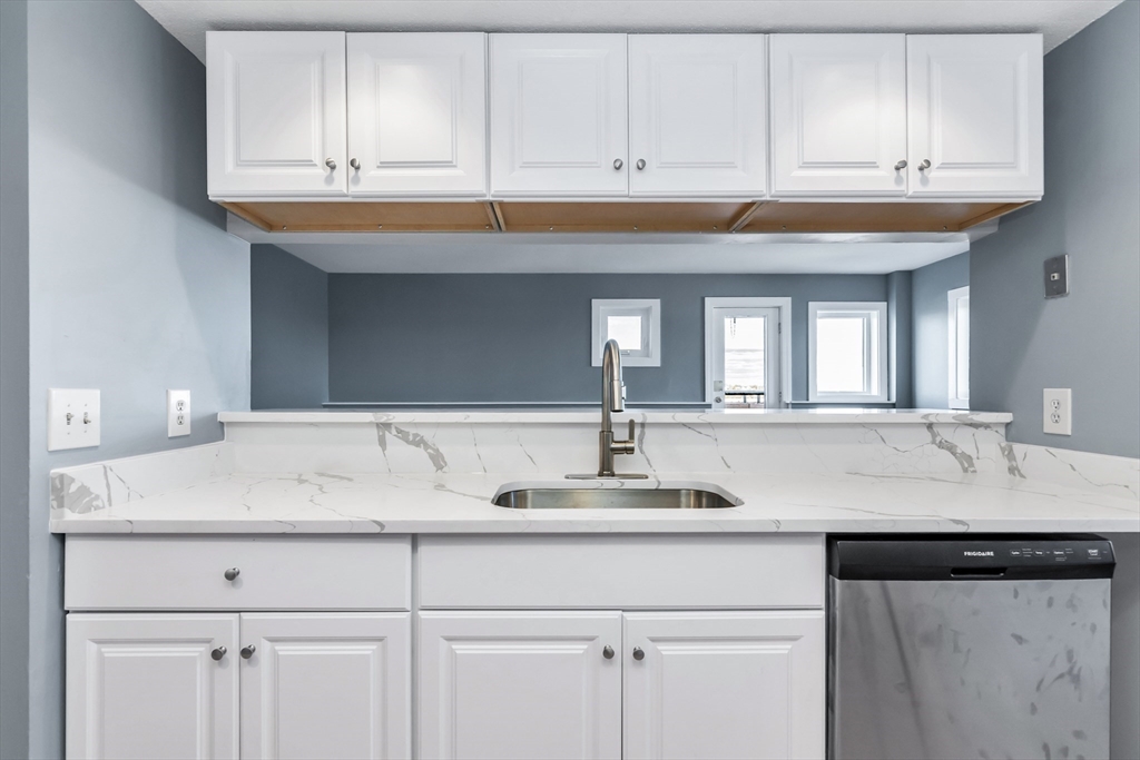 165 Cottage Street, Unit 711 Chelsea, MA 02150 - Photo 2 of 39 a kitchen with granite countertop a sink and cabinets