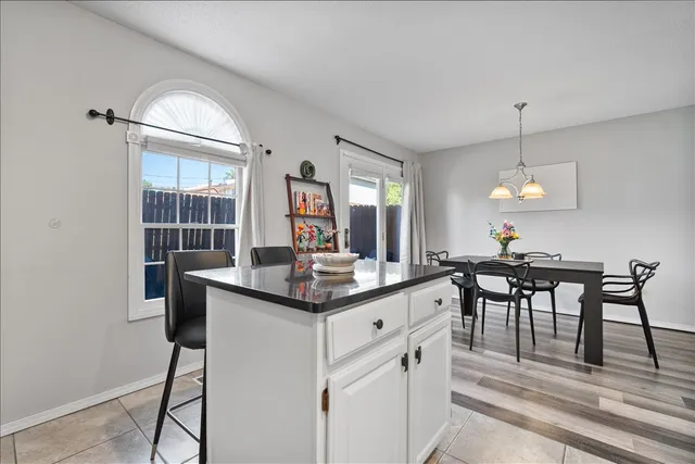 a dining hall with stainless steel appliances granite countertop furniture a fireplace and a chandelier