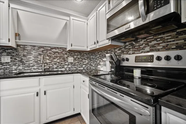 a kitchen with granite countertop a stove and a sink
