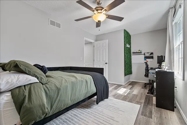 a bedroom with a bed and wooden floor